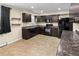 Modern kitchen with dark cabinets, black appliances, and tile flooring providing a sleek and stylish space at 8487 W 62Nd Pl, Arvada, CO 80004