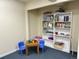 Carpeted basement playroom with blue chairs, a table filled with art supplies, and toy-filled bookshelves at 10565 Kicking Horse Dr, Littleton, CO 80125