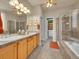 Well-lit bathroom with double vanity, walk-in shower, soaking tub, and walk-in closet at 10565 Kicking Horse Dr, Littleton, CO 80125