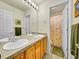 Bright bathroom featuring a double sink vanity with a shower and toilet in a separate room at 10565 Kicking Horse Dr, Littleton, CO 80125