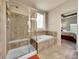 A well-appointed bathroom features a glass-enclosed shower, a soaking tub, and access to a bedroom at 10565 Kicking Horse Dr, Littleton, CO 80125