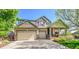 Charming two-story home featuring a welcoming front porch and a spacious three-car garage at 10565 Kicking Horse Dr, Littleton, CO 80125