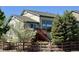 Beautiful exterior view of a two-story home, showcasing mature trees and a charming wooden fence at 10565 Kicking Horse Dr, Littleton, CO 80125