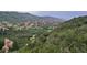 Scenic landscape with jagged red rock formations nestled among green trees, set against rolling, verdant hills at 10565 Kicking Horse Dr, Littleton, CO 80125