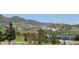 Scenic landscape view showcasing a tranquil lake and architectural buildings nestled among rolling green hills at 10565 Kicking Horse Dr, Littleton, CO 80125