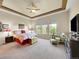 Spacious main bedroom with tray ceiling, three windows, and comfortable sitting area at 10565 Kicking Horse Dr, Littleton, CO 80125