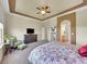 Spacious main bedroom boasts tray ceiling, furnishings, and en-suite bathroom access at 10565 Kicking Horse Dr, Littleton, CO 80125
