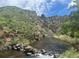 Picturesque river view amidst rocky terrain with lush vegetation, perfect for nature lovers at 10565 Kicking Horse Dr, Littleton, CO 80125