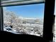 Bright view of snow-covered landscape from window, showcasing serene outdoor setting at 10565 Kicking Horse Dr, Littleton, CO 80125