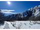 Snowy landscape featuring towering, snow-covered cliffs under a bright blue sky, creating a stark and serene scene at 10565 Kicking Horse Dr, Littleton, CO 80125