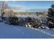 Picturesque winter view of a lake with snow-covered bushes in the foreground creating a serene, natural landscape at 10565 Kicking Horse Dr, Littleton, CO 80125
