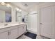 Modern bathroom with double sinks, sleek white cabinetry, a walk-in shower, and tiled floors for a spa-like experience at 7702 E 159Th Ave, Thornton, CO 80602