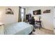 Well-lit bedroom with a window, black shelving unit, desk, and a television mounted to the wall at 7702 E 159Th Ave, Thornton, CO 80602
