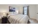Bright bedroom featuring neutral decor, striped bedding, and a scenic picture above the bed at 7702 E 159Th Ave, Thornton, CO 80602