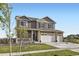 A daytime view of a two-story home showcasing a covered front porch and three-car garage at 7702 E 159Th Ave, Thornton, CO 80602