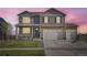 Two-story home showcasing a covered front porch and three-car garage at 7702 E 159Th Ave, Thornton, CO 80602