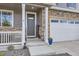 Charming covered porch leads to the front door with a view of the attached three-car garage at 7702 E 159Th Ave, Thornton, CO 80602