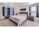 Inviting main bedroom with two windows, side tables, and a bed with a floral print, offering a relaxing retreat at 7702 E 159Th Ave, Thornton, CO 80602