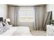 Bright bedroom featuring a large window, neutral palette, stylish curtains and contemporary decor at 16300 Paris Way, Brighton, CO 80602
