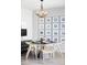 Bright dining area featuring hardwood floors, a round table, modern chandelier and decorative wall art at 16300 Paris Way, Brighton, CO 80602