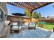 Relaxing backyard deck features modern seating, a pergola with string lights, and a picnic table at 2950 Hudson St, Denver, CO 80207