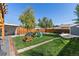 Spacious backyard with lush lawn, mature trees, hammock, play structure, and picnic table at 2950 Hudson St, Denver, CO 80207