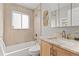 Neutral bathroom featuring a shower-tub combo, single sink vanity, and window providing natural light at 2950 Hudson St, Denver, CO 80207