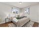 Bright bedroom with hardwood floors, with windows and a stylishly decorated bed and neutral colored walls at 2950 Hudson St, Denver, CO 80207
