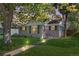 Charming one-story home featuring a well-maintained lawn, walkway lighting, and mature trees at 2950 Hudson St, Denver, CO 80207
