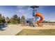 A modern playground area with slides, climbing structures and swings surrounded by green space at 2950 Hudson St, Denver, CO 80207