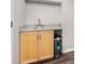 Convenient wet bar area with light wood cabinets and stone countertops at 2950 Hudson St, Denver, CO 80207