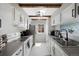 Bright kitchen featuring white cabinets, stainless steel appliances, and wood beam accents at 7700 W Glasgow Pl # 11C, Littleton, CO 80128