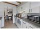Kitchen leading to dining room with white cabinets, stainless steel appliances, and wood beam accents at 7700 W Glasgow Pl # 11C, Littleton, CO 80128