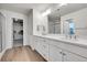 Bathroom with dual vanity, quartz countertops, and a glass enclosed shower, plus access to a walk-in closet at 3888 Grand Baker St, Aurora, CO 80019