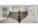 Bright upstairs hallway with dark wood railings and carpeting leading to the bedrooms at 3888 Grand Baker St, Aurora, CO 80019