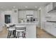 Modern kitchen with white cabinets, stainless steel appliances, and a spacious island with bar seating at 3888 Grand Baker St, Aurora, CO 80019