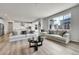 Open-concept living room and kitchen with hardwood floors, stylish furnishings, and bright natural light at 3888 Grand Baker St, Aurora, CO 80019