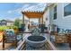 Cozy backyard patio with stylish outdoor furniture, a fire pit, and a pergola with string lights at 14066 Ivanhoe Ct, Thornton, CO 80602