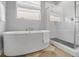 Modern bathroom features a soaking tub and glass enclosed shower with beautiful natural lighting at 14066 Ivanhoe Ct, Thornton, CO 80602