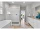 Bright bathroom boasts soaking tub, glass shower, and double vanity with granite countertops at 14066 Ivanhoe Ct, Thornton, CO 80602
