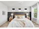 Sunlit bedroom features stylish accent wall, plush bedding, and ample natural light at 14066 Ivanhoe Ct, Thornton, CO 80602