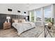 Bright bedroom features a decorative accent wall, large windows, and wood-look flooring at 14066 Ivanhoe Ct, Thornton, CO 80602