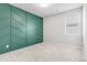 Bedroom with custom green accent wall, carpet flooring, and natural light from a window at 14066 Ivanhoe Ct, Thornton, CO 80602