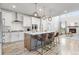 Bright, open kitchen with large island, pendant lighting, stainless steel appliances, and fireplace view at 14066 Ivanhoe Ct, Thornton, CO 80602