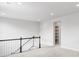 Upstairs landing features plush carpet, white walls and dark stained wood railing at 14066 Ivanhoe Ct, Thornton, CO 80602