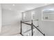Upstairs landing with carpeted floor, natural lighting and dark stained wood railing at 14066 Ivanhoe Ct, Thornton, CO 80602