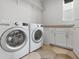 Bright laundry room with front loading washer and dryer and storage cabinets at 14066 Ivanhoe Ct, Thornton, CO 80602