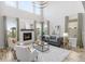 Sun-filled living room boasts high ceilings, a cozy fireplace, and stylish neutral furniture at 14066 Ivanhoe Ct, Thornton, CO 80602
