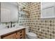 Charming powder room featuring patterned wallpaper, a modern vanity, and stylish fixtures at 14066 Ivanhoe Ct, Thornton, CO 80602
