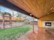 Inviting outdoor space with a covered patio, stone fireplace, tiered garden beds, and lush green lawn for relaxation and entertainment at 7217 S Zephyr Way, Littleton, CO 80128